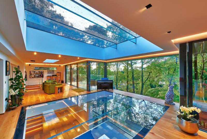 Ultra modern conservatory extension with glass roof, glass floor and walls of glass.